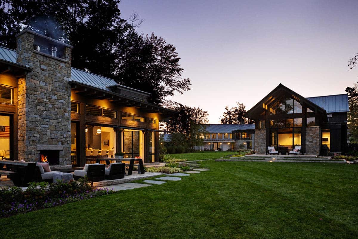 Dusk view of stone fireplace patio between two structures