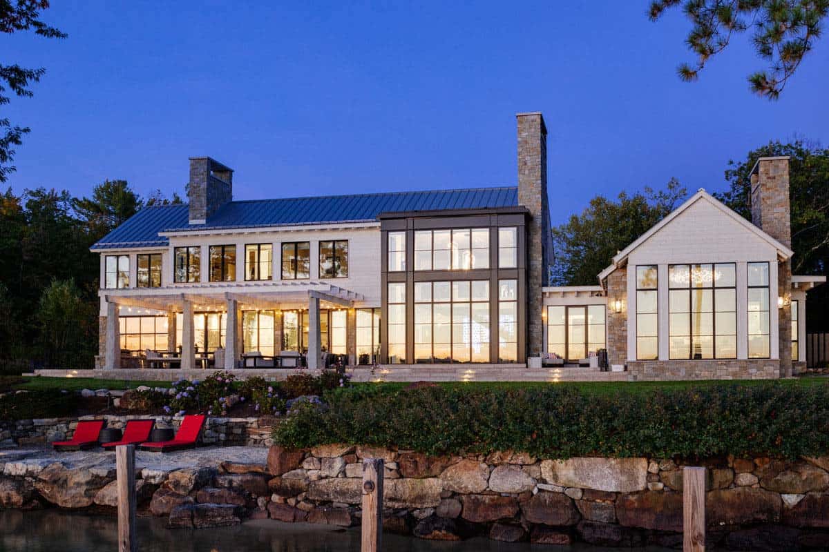 Twilight lakefront view with red lounge chairs on rock ledge