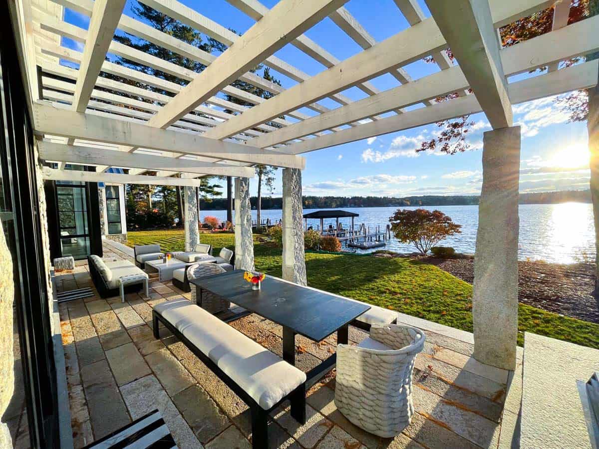 Pergola-covered dining patio overlooking the lake at sunset