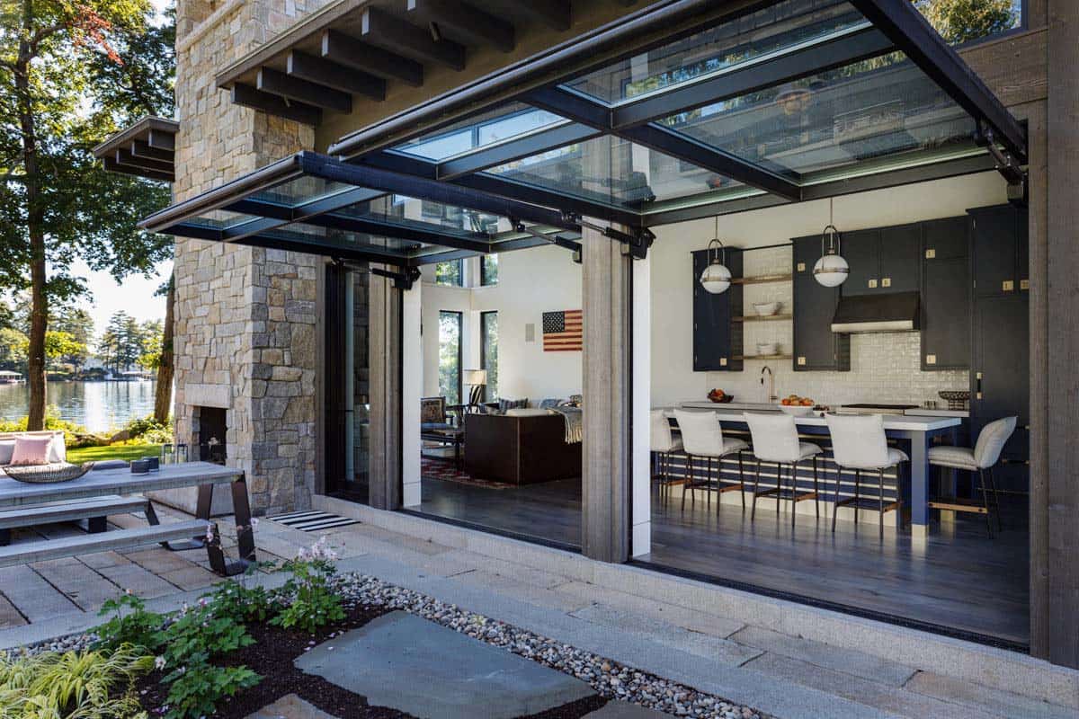 Retractable glass wall opening to kitchen with navy cabinetry