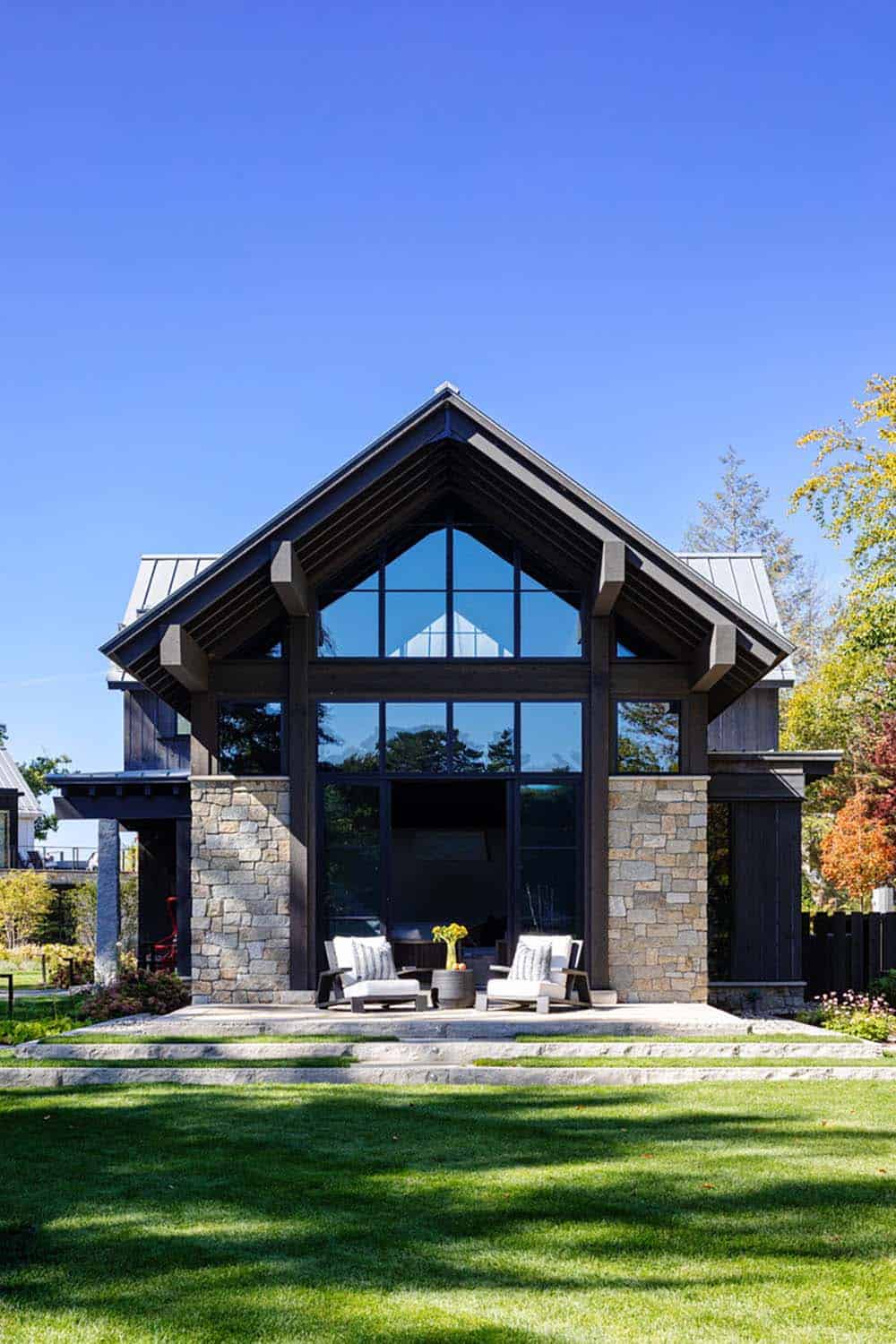 Barn gable end with floor-to-ceiling windows and patio seating