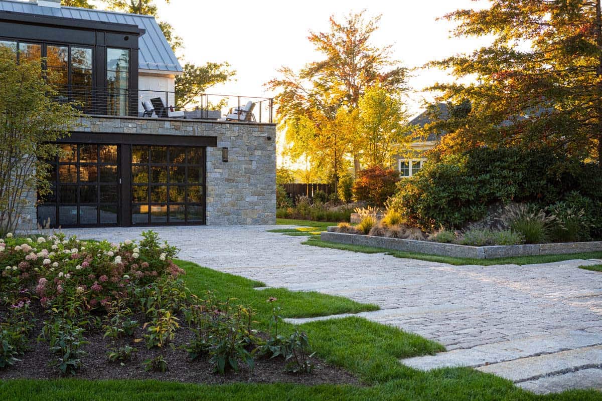 Motor court with garage doors and stone paver driveway