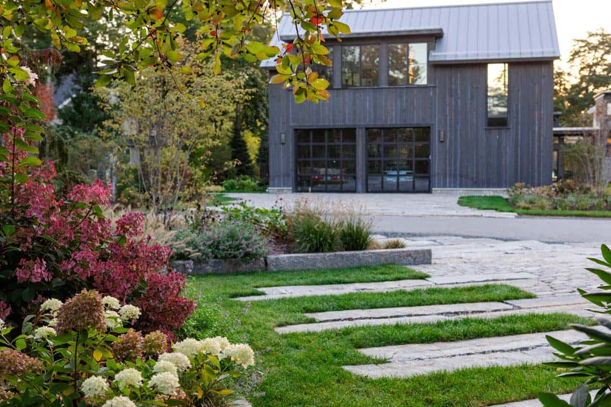 Barn garage doors viewed across stone paver driveway