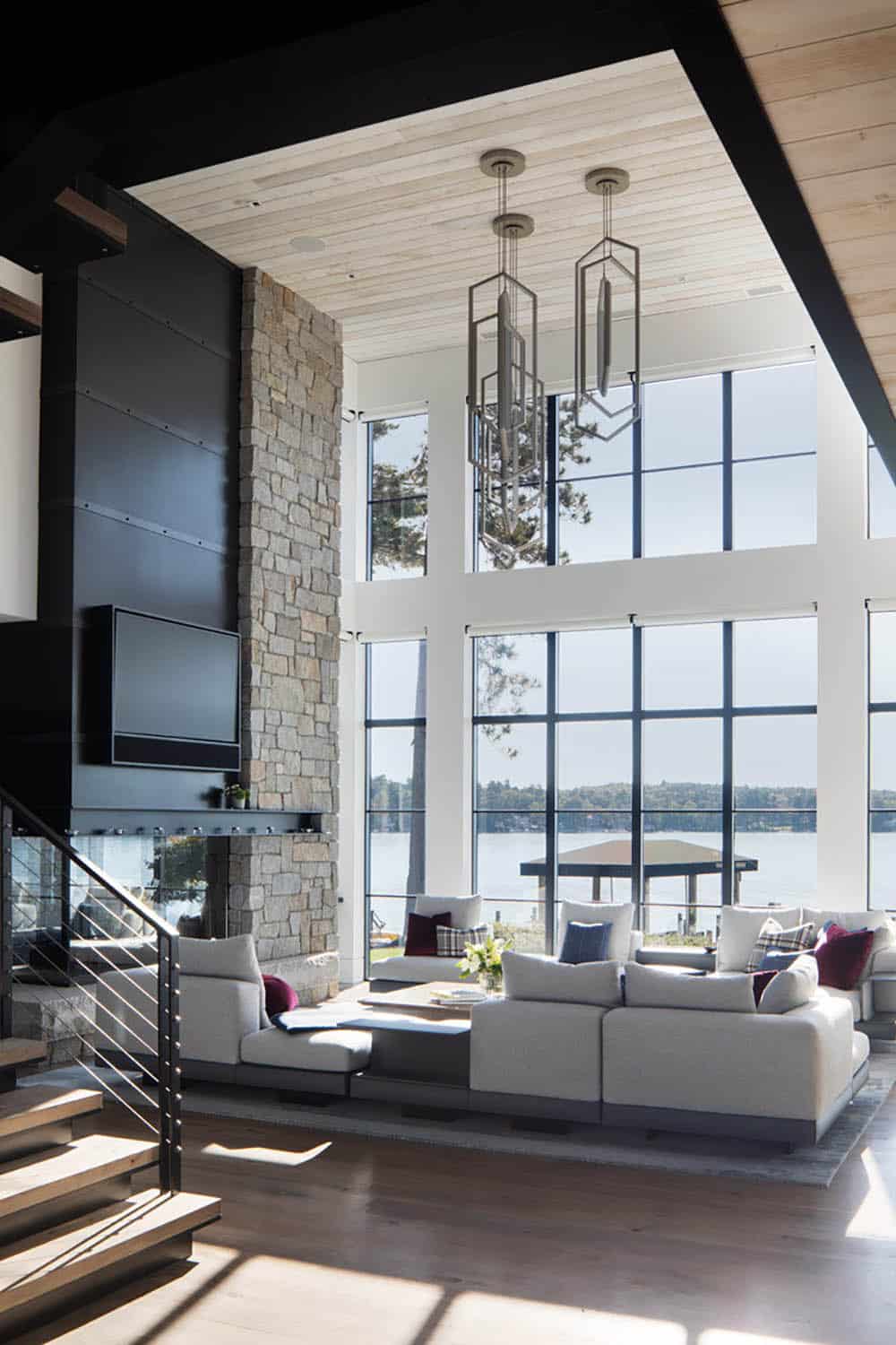 Living room interior with stone fireplace and lake view