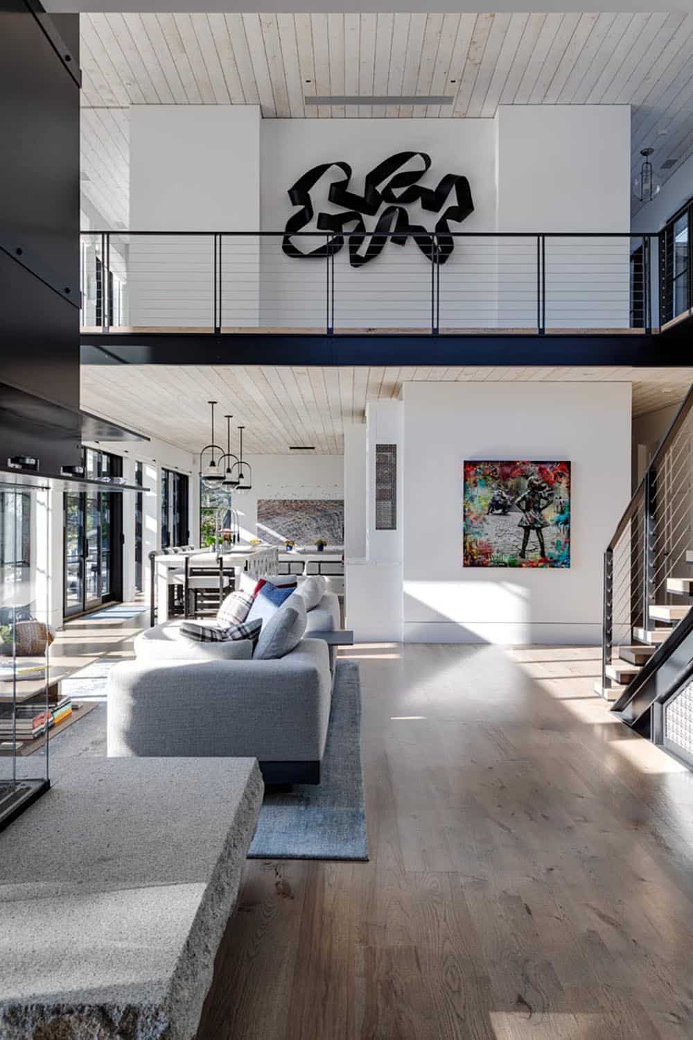Two-story living area with steel railing and modern artwork