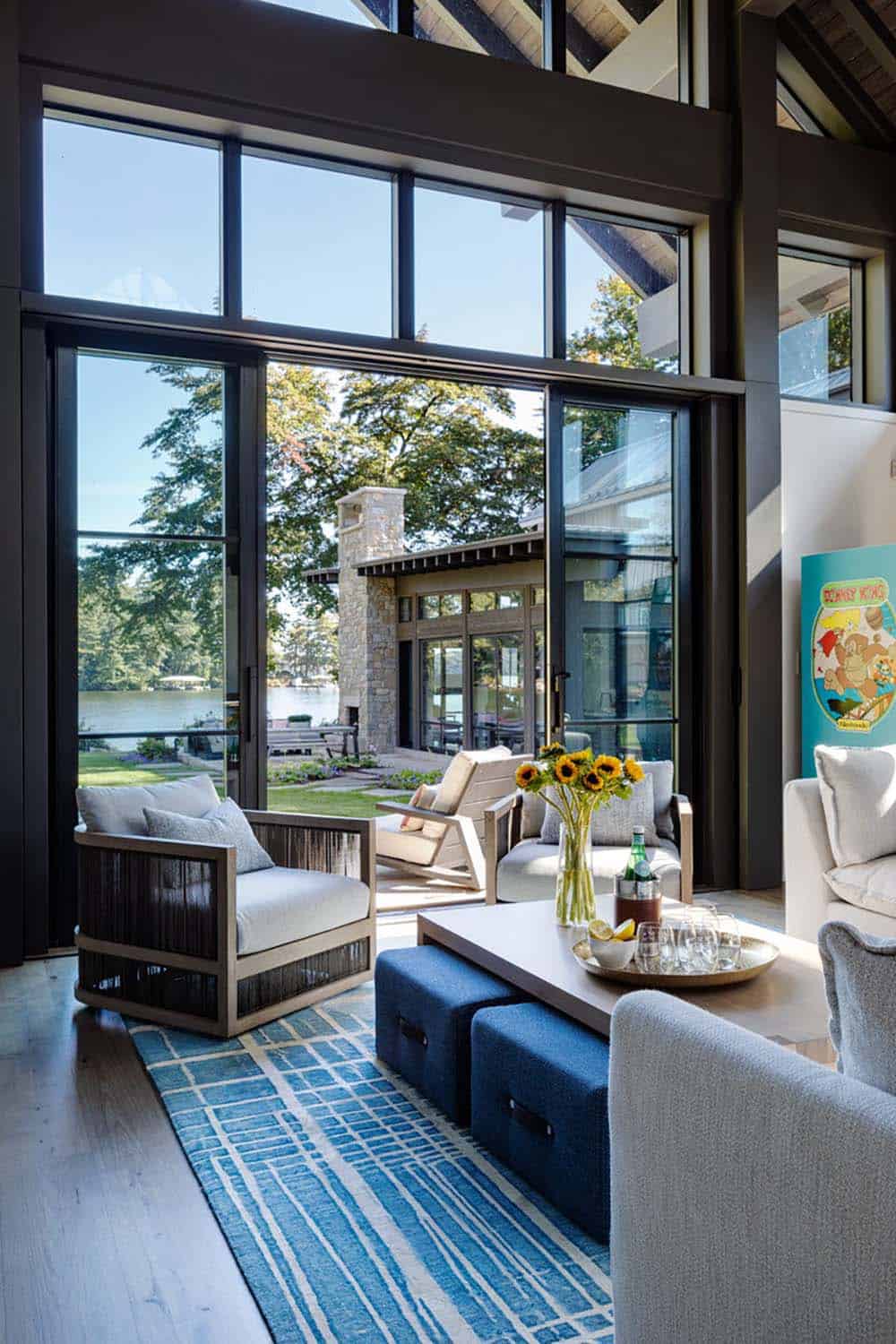 Sitting area with blue rug and glass doors to lake