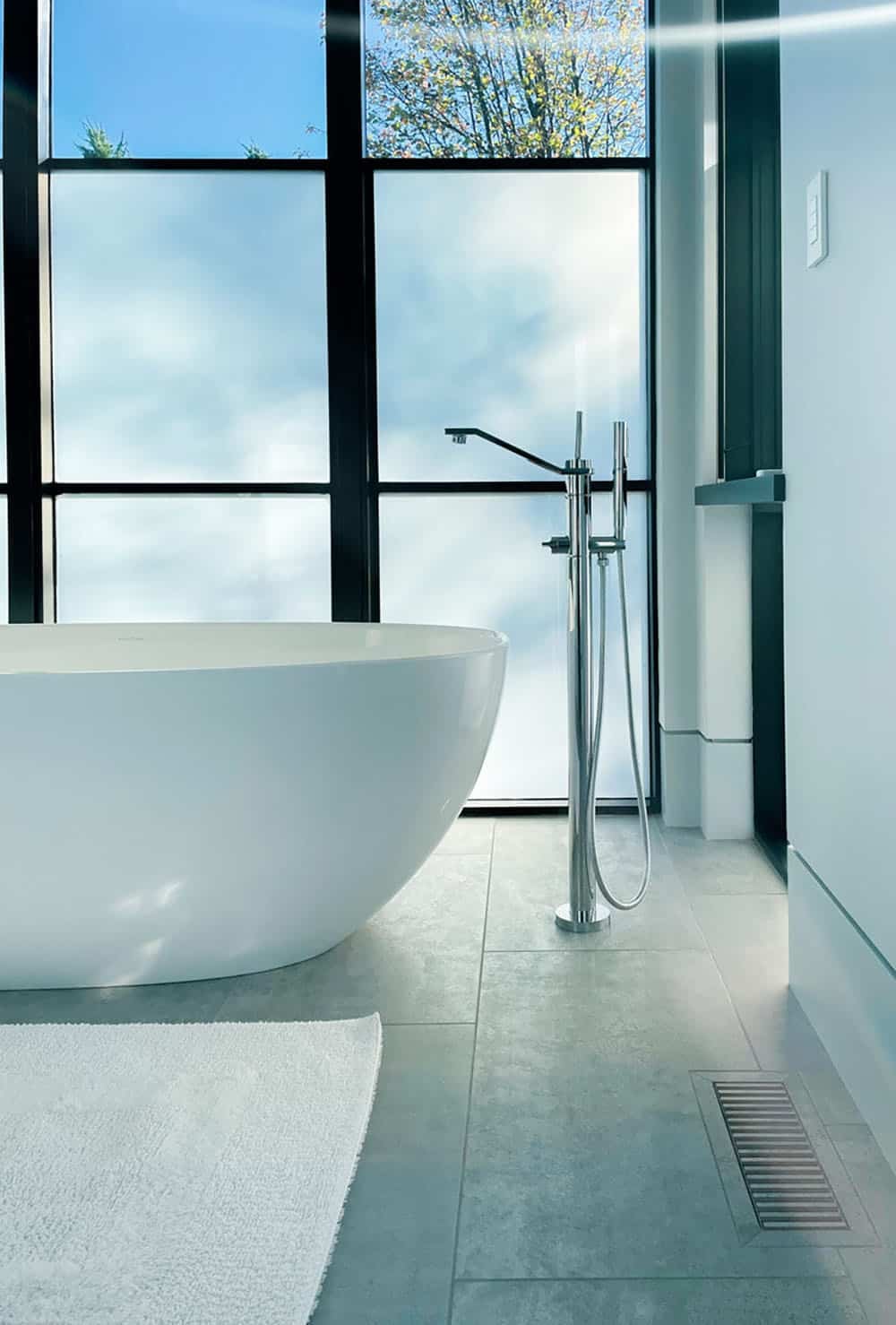 Freestanding tub detail with floor-mount faucet and tile flooring