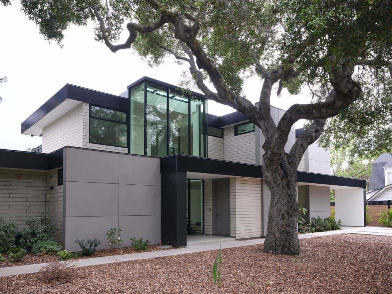 Glass lantern volume rising above the entry, framed by oak branches