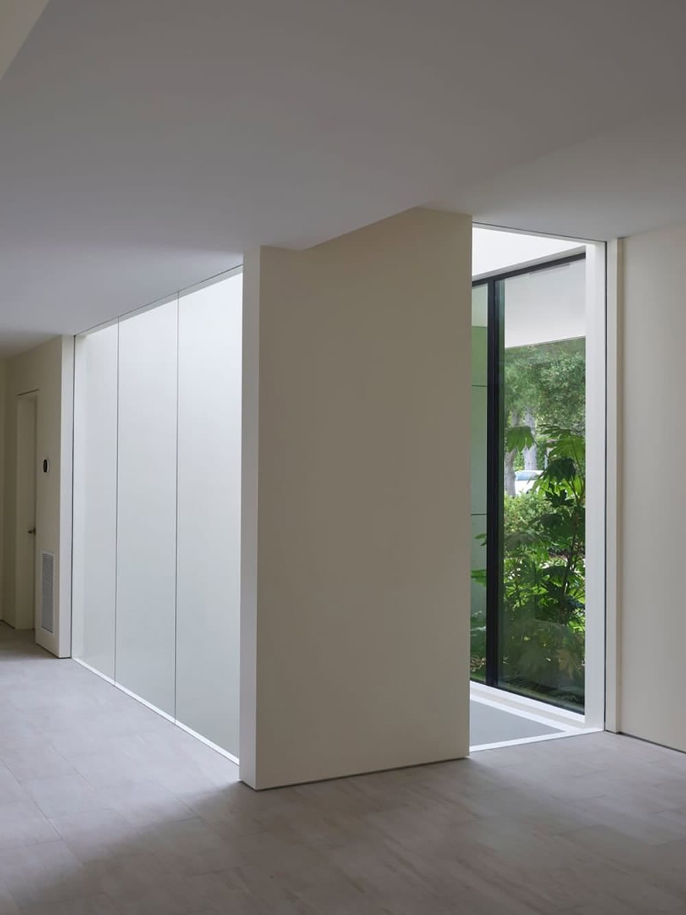 Basement hallway lit by the exterior light well and glass door