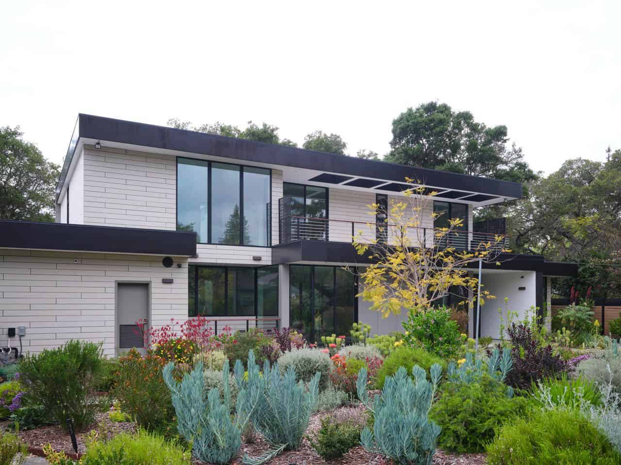 Rear exterior of the home with roof deck, drought-tolerant landscaping in bloom