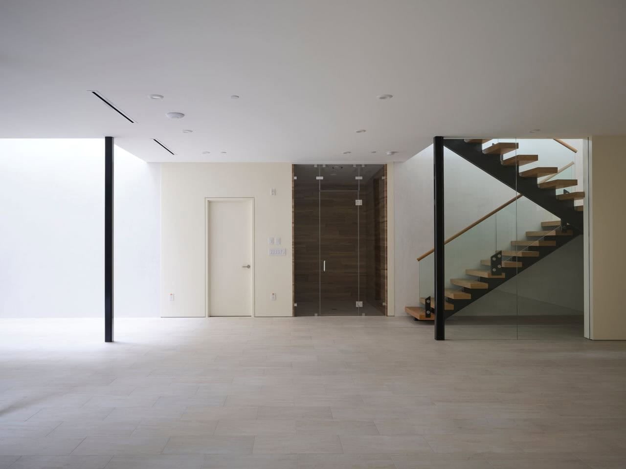 Daylit basement space showing the light well and glass stairwell enclosure