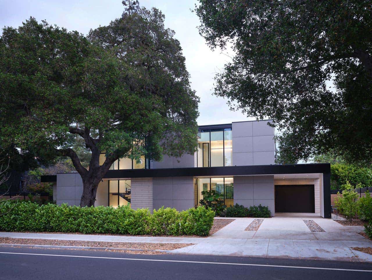 Twilight view of the Lantern House exterior glowing beneath the oak canopy