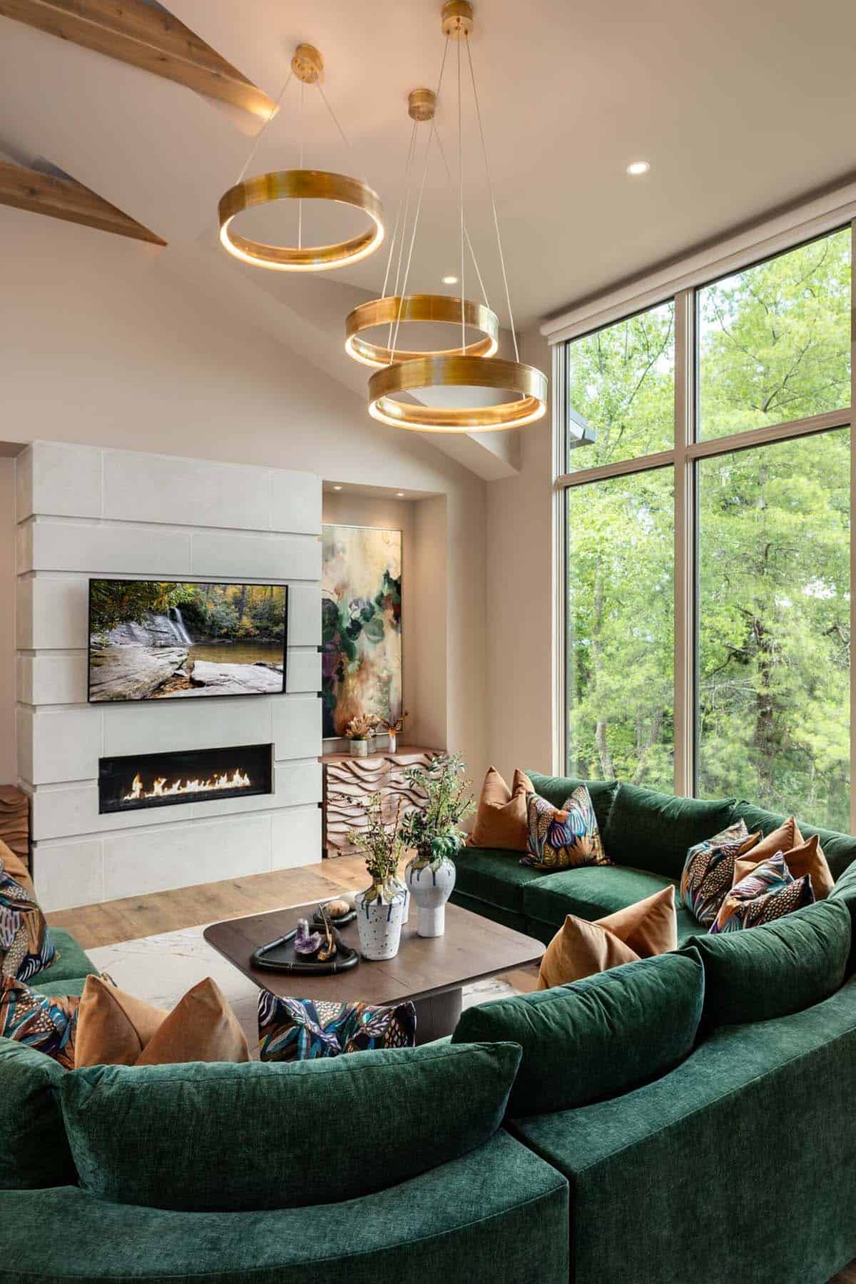 Vaulted ceiling living room corner with brass ring pendants over green sofa