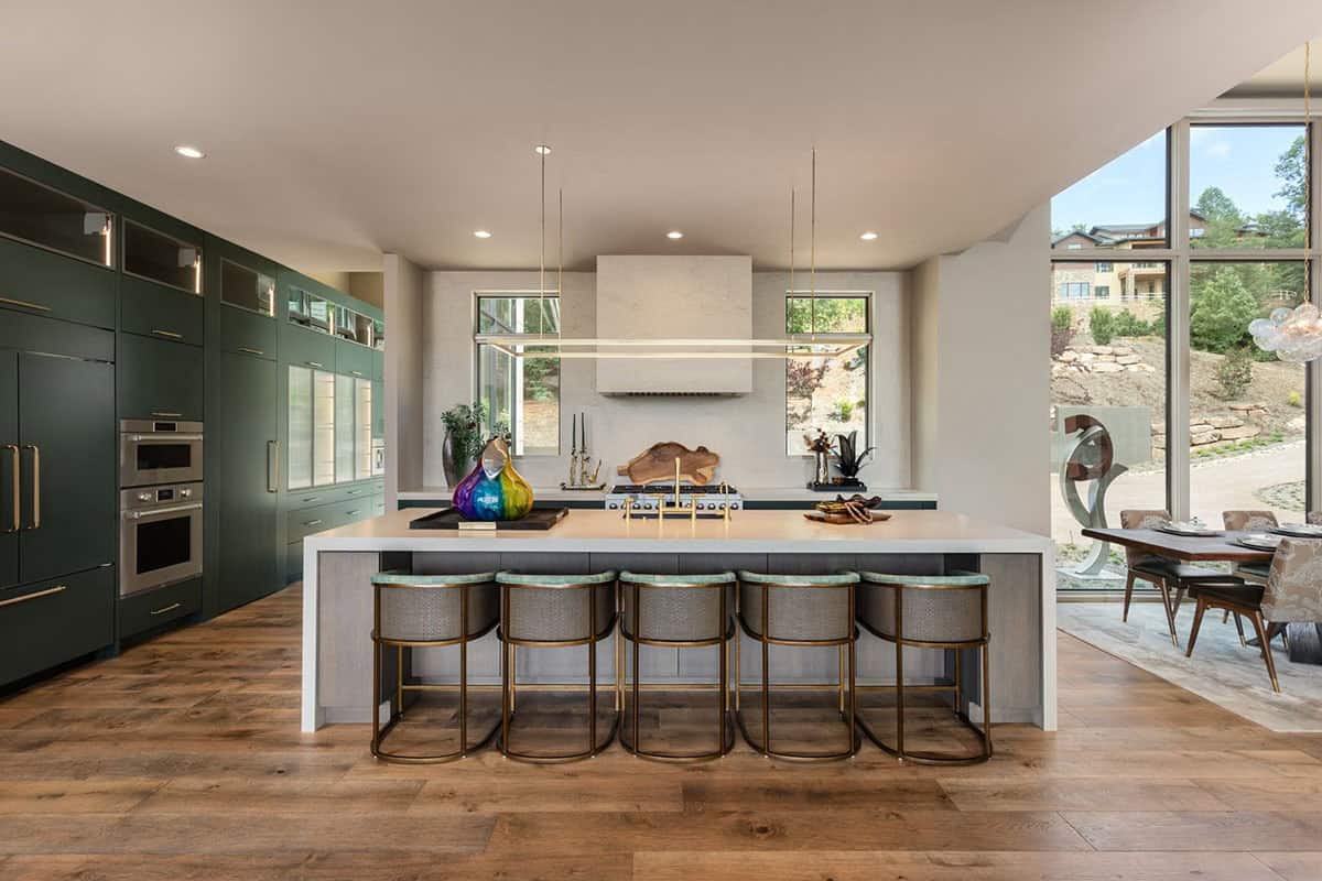 Kitchen island view toward plaster hood and green perimeter cabinetry