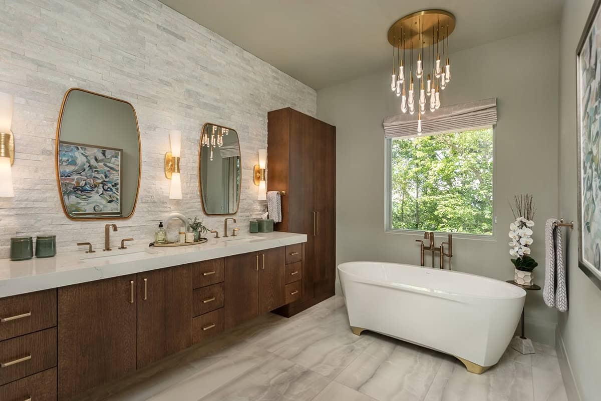 Primary bathroom double vanity with stacked stone wall and gold pendant cluster