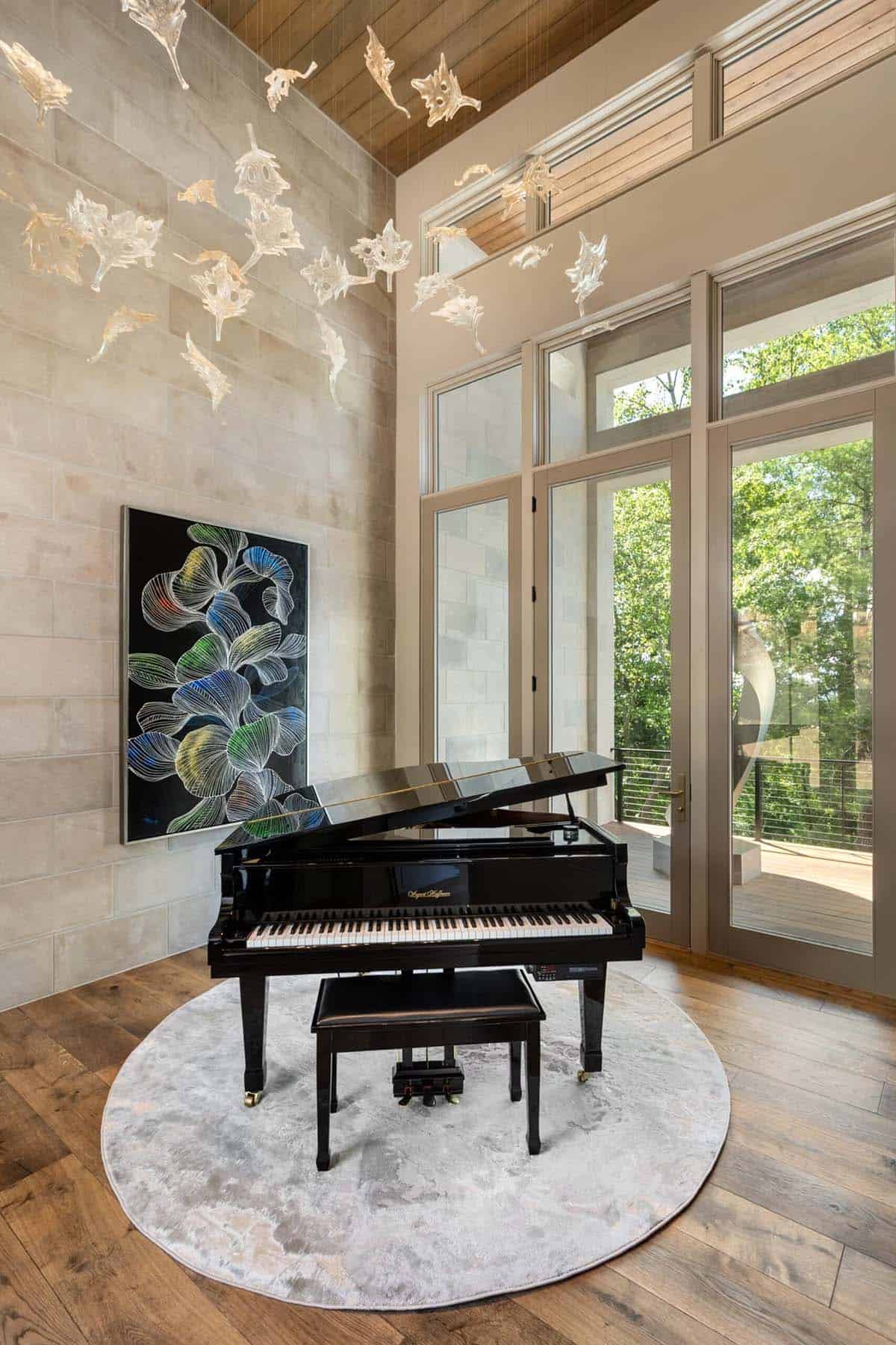 Two story music room with black grand piano and blown glass sculpture