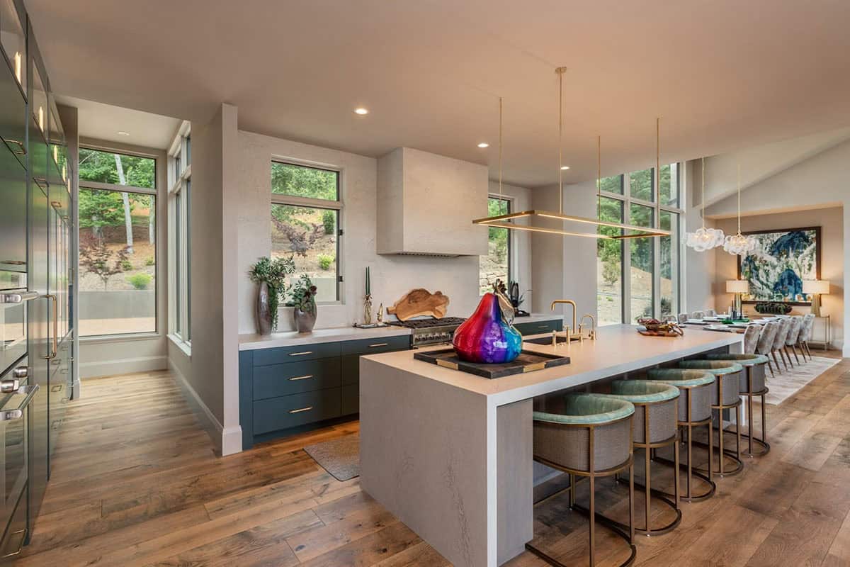 Kitchen island and dining area with navy cabinetry and colorful glass decor