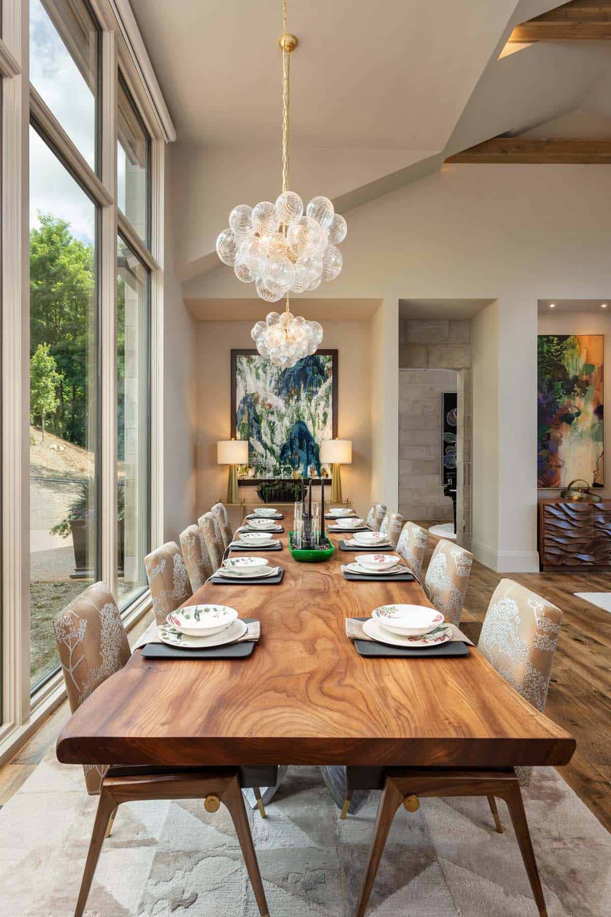 Live edge wood dining table set beneath cluster of glass bubble chandeliers