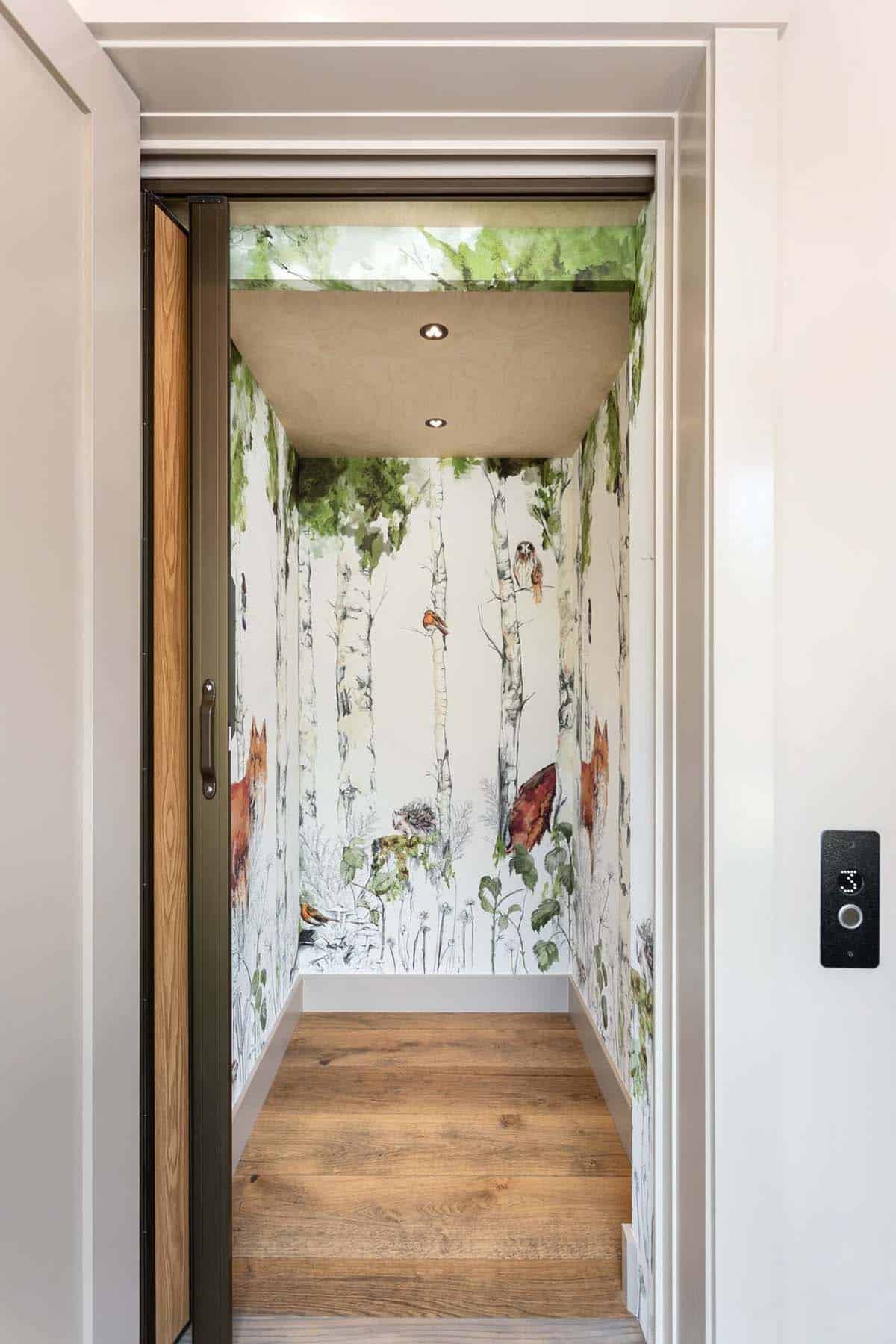 Elevator interior wrapped in woodland fox and birch tree wallpaper