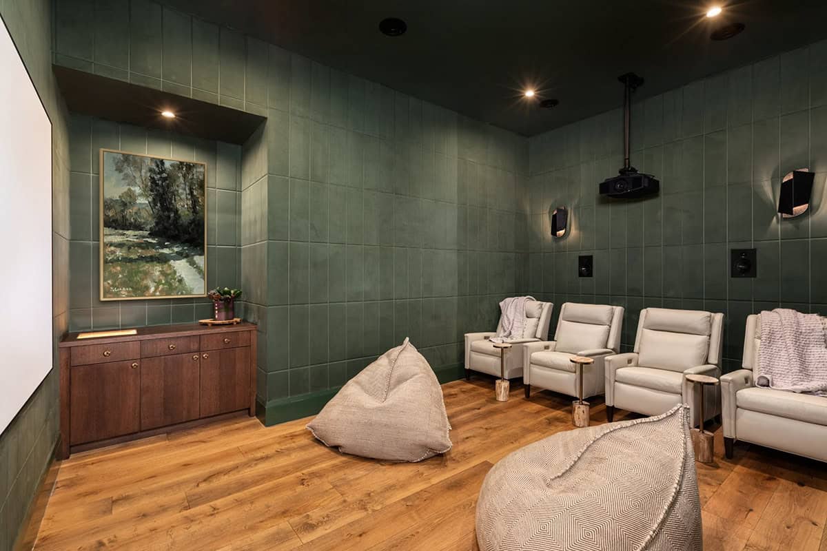 Home theater with green tile walls, bean bags, and leather recliners
