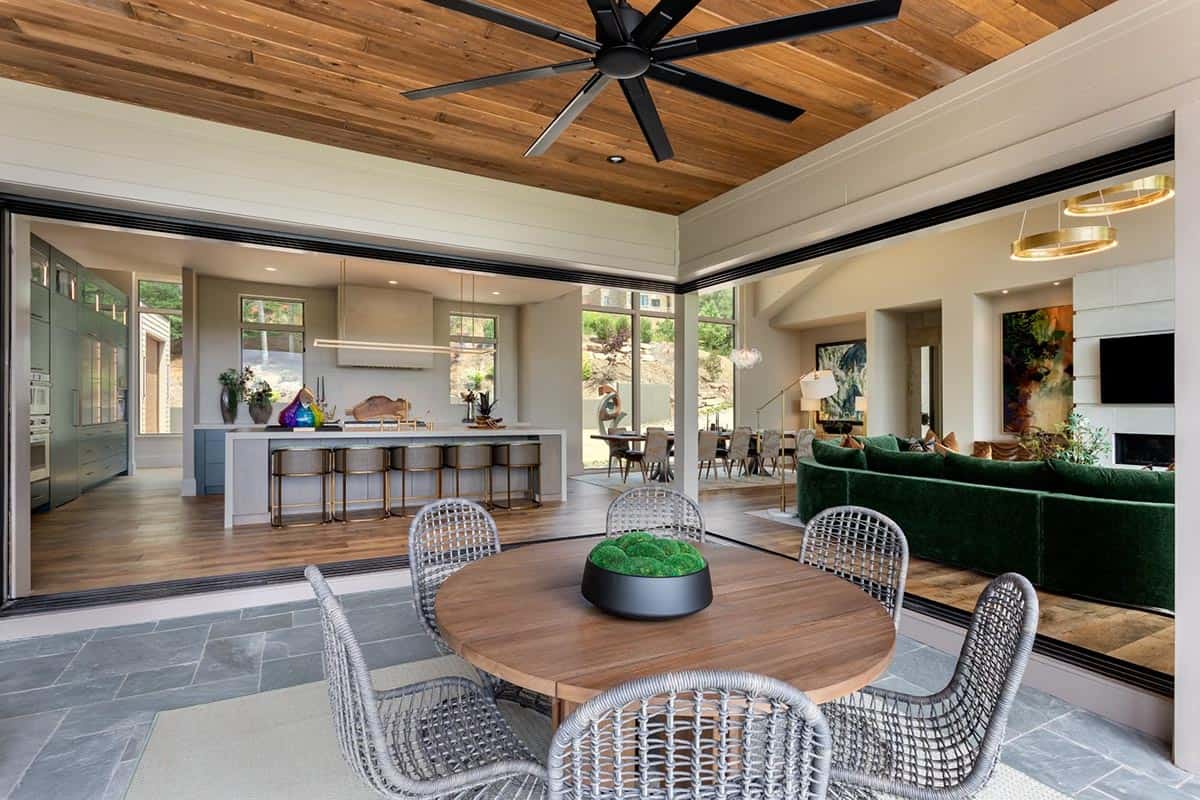 Covered patio dining table framed by open pocket doors to kitchen