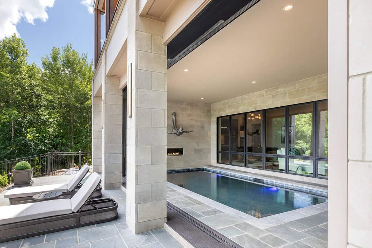 Exterior view of indoor pool room framed by black steel windows