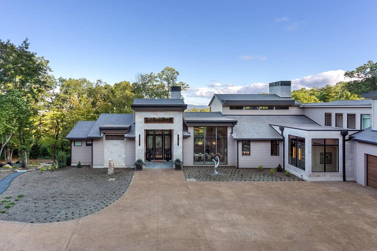 Modern mountain home exterior with stone tower entry and gravel motor court