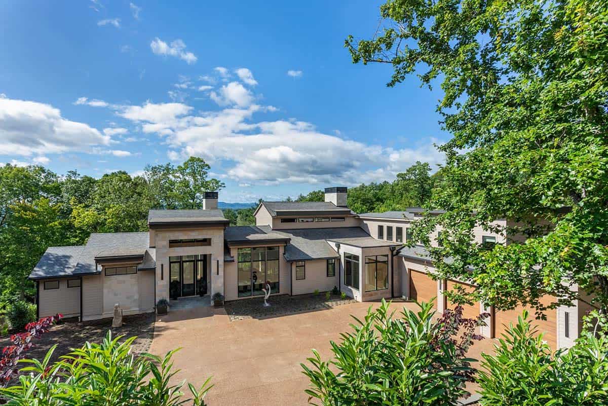Aerial view of home exterior with stone chimneys and circular driveway