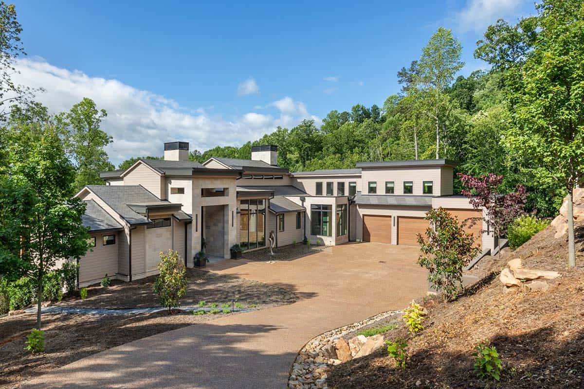 Aerial view of sprawling home exterior framed by wooded hillside