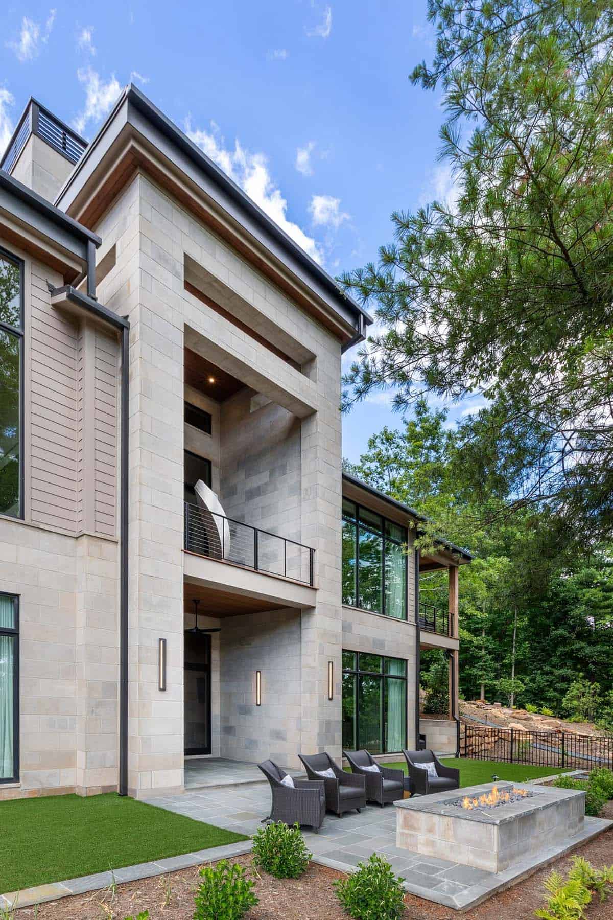 Vertical stone tower exterior with balcony sculpture and wicker seating below