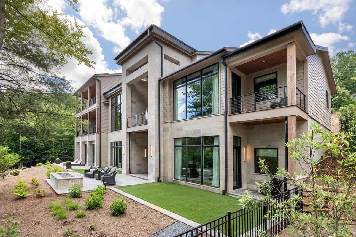 Two story exterior with stone base, glass walls, and covered balconies
