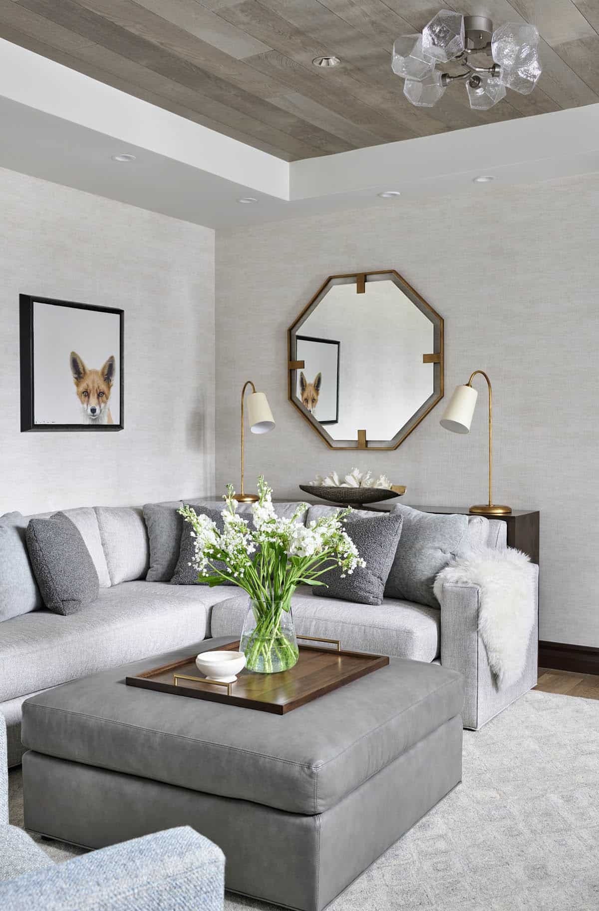 Living room seating area with gray sectional, octagonal mirror, and fox art print
