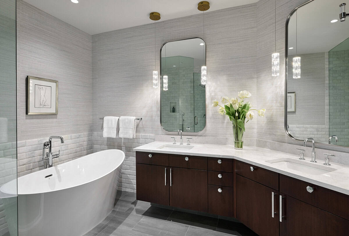 Primary bathroom with freestanding tub, dual vanities, and pendant lighting