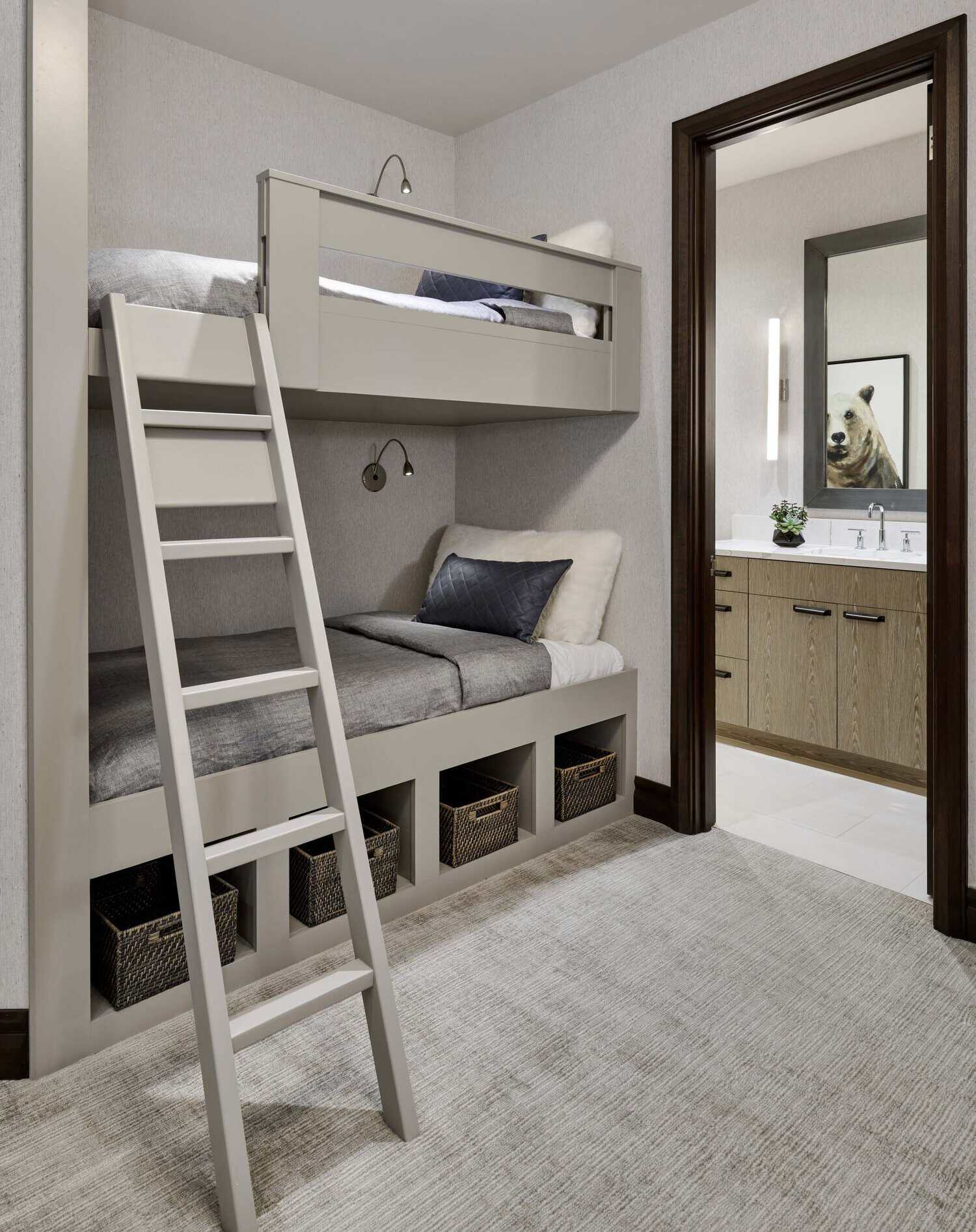 Built-in bunk beds with storage cubbies, adjoining bathroom visible through doorway