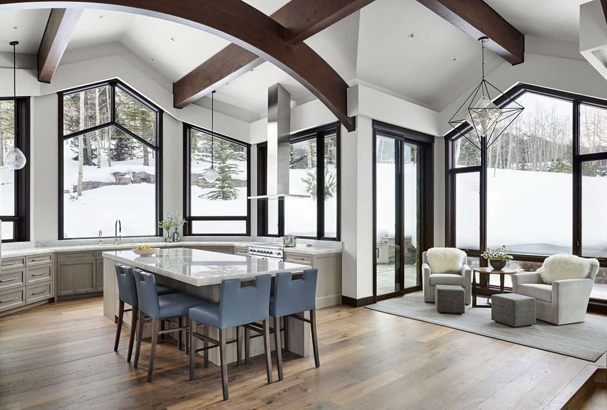Open kitchen and sitting area with vaulted wood-beamed ceiling and geometric pendant light