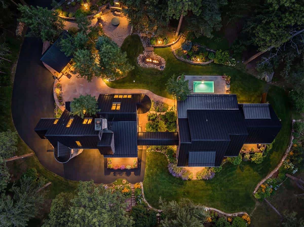 Aerial view of black standing-seam roofline with pool and firepit
