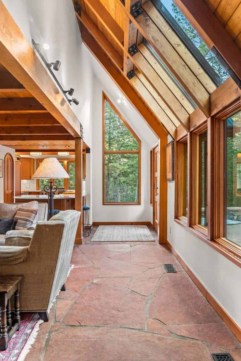 Vaulted entry hall features exposed timber beams and tall windows