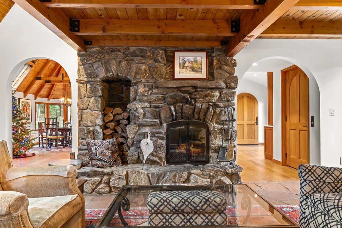Rustic stone fireplace with firewood niche between arched doorways