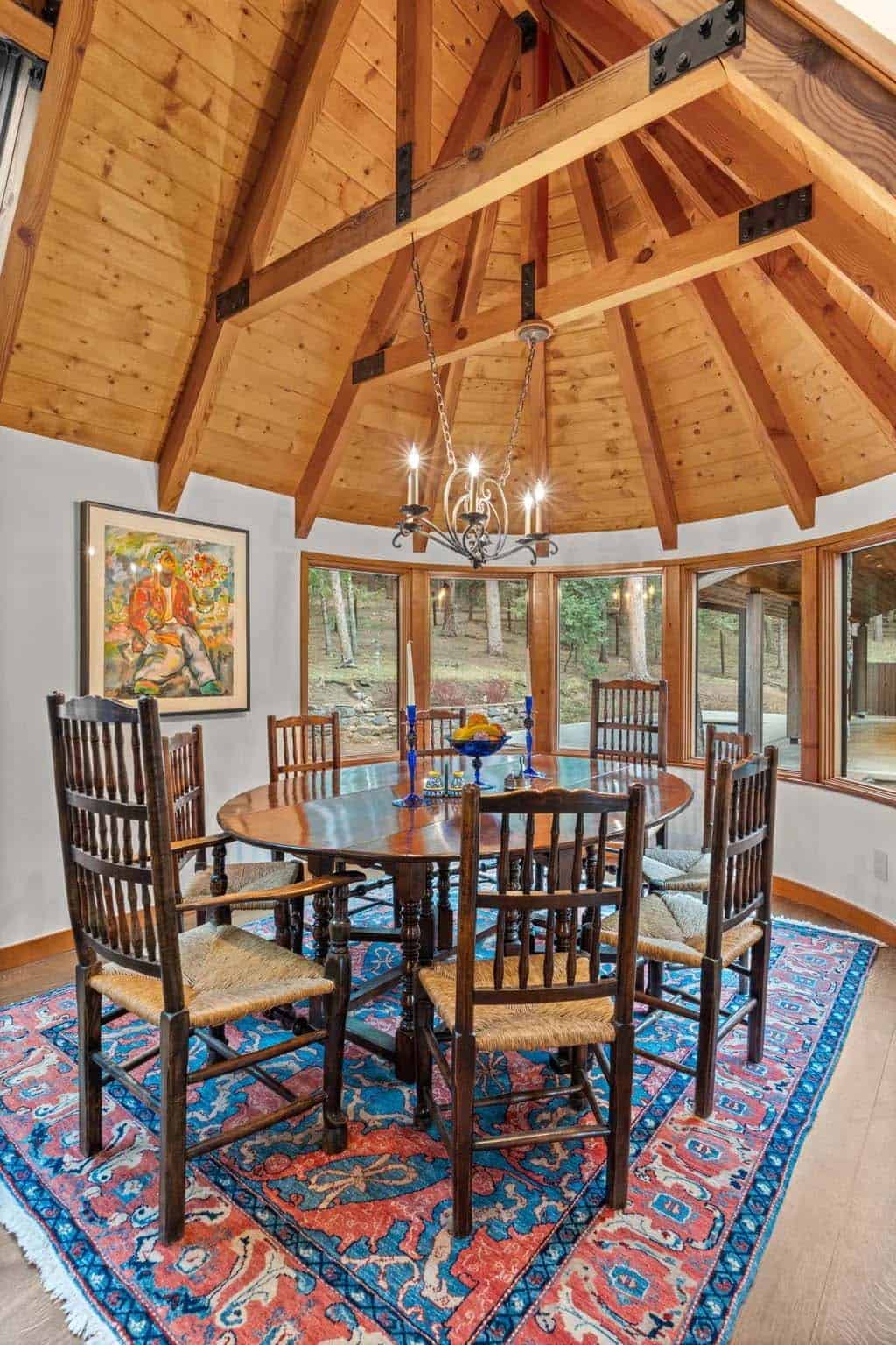 Round dining nook with timber ceiling and colorful woven rug