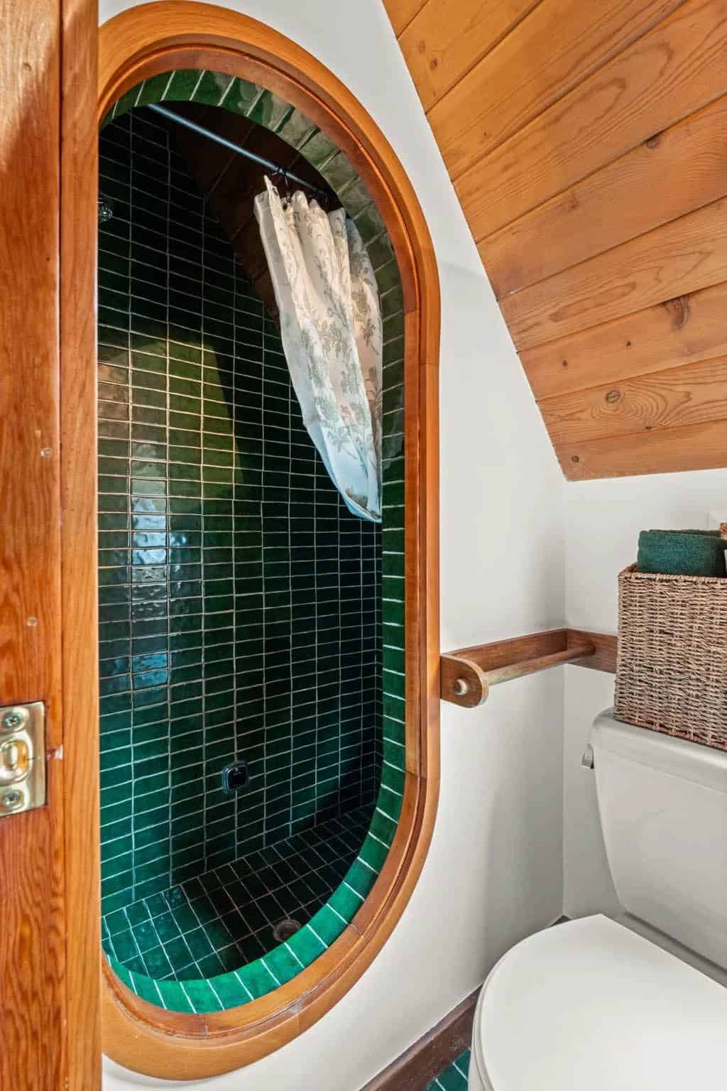 Curved opening into a green tiled shower stall