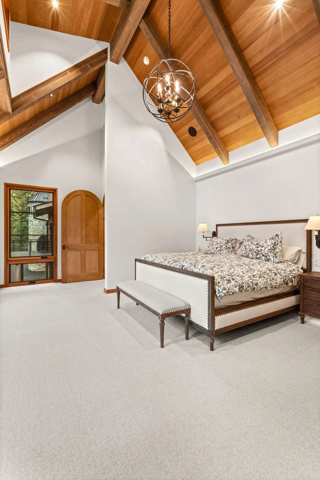Primary suite with vaulted wood ceiling and orb chandelier
