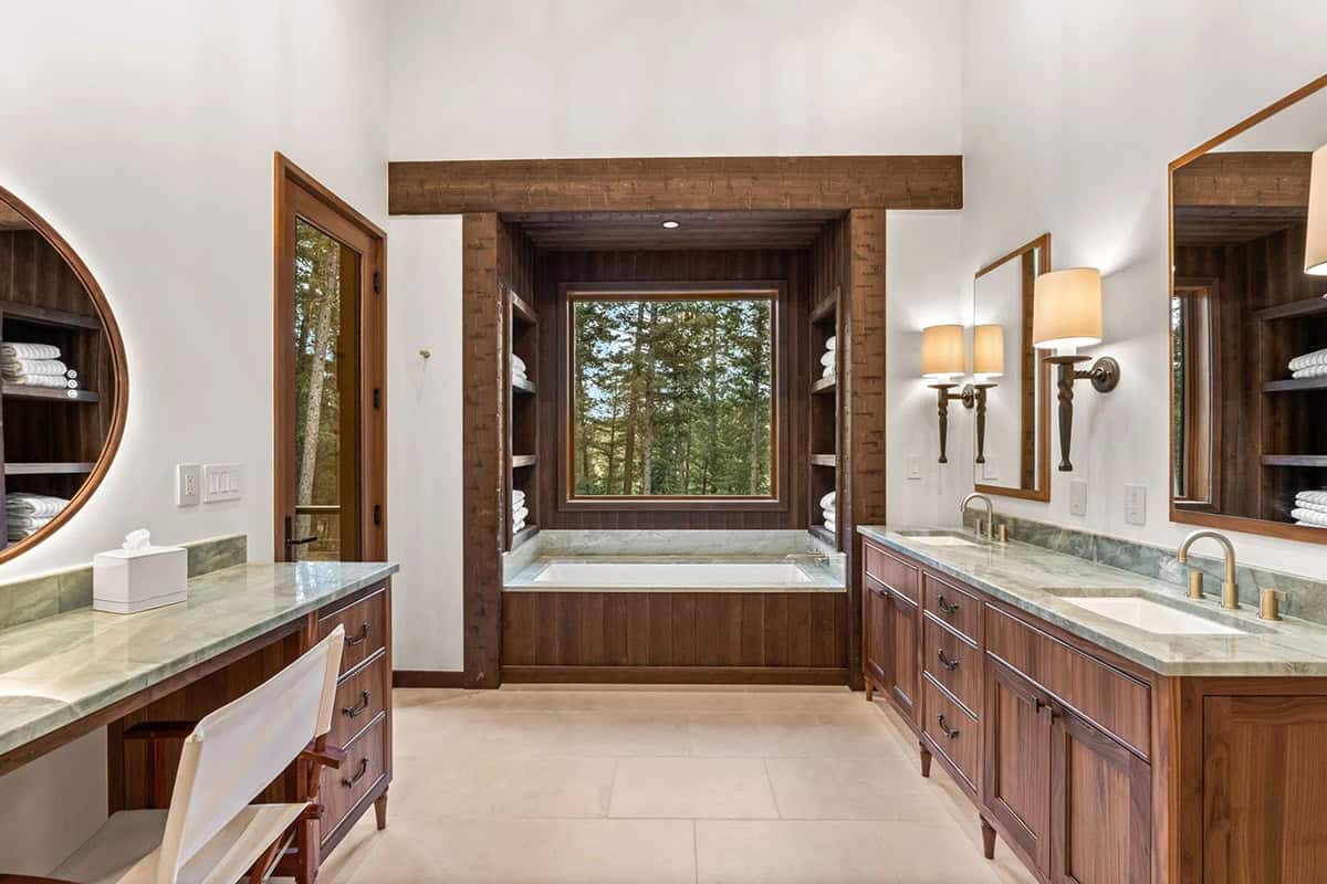 Primary bath features a wood-framed soaking tub and dual vanities