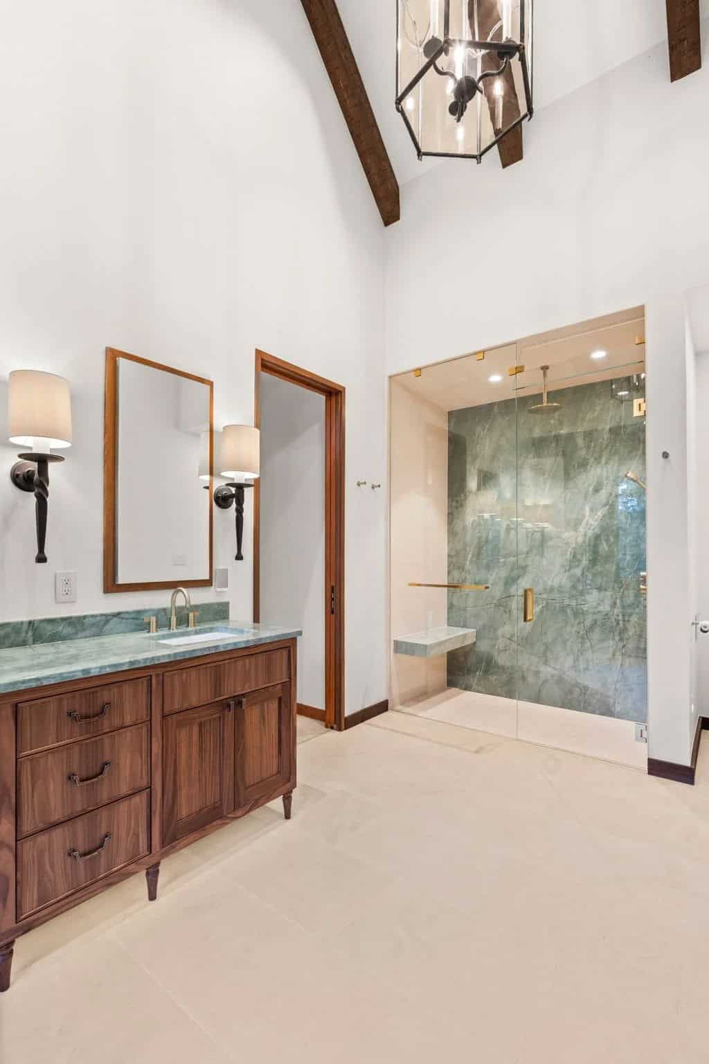 Bathroom vanity sits beside a green marble steam shower