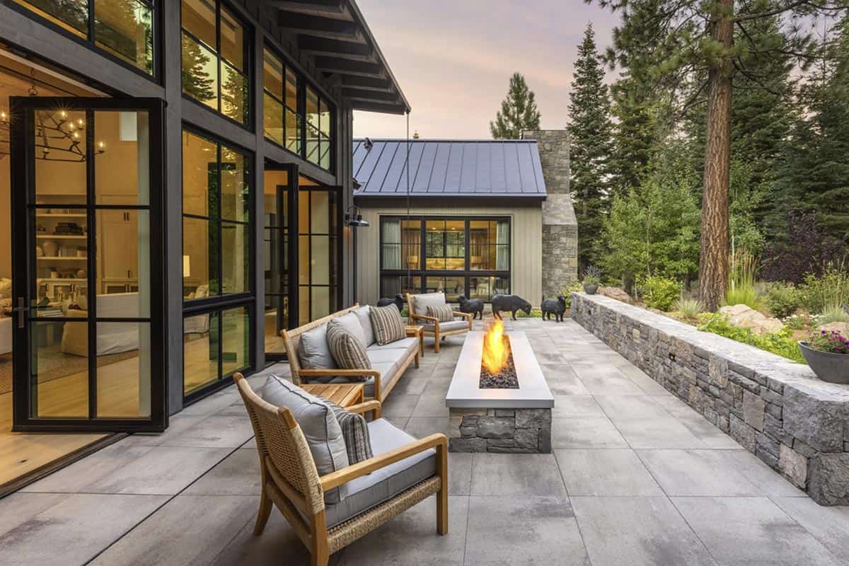 Outdoor patio with fire pit, wicker furniture, and stone retaining wall