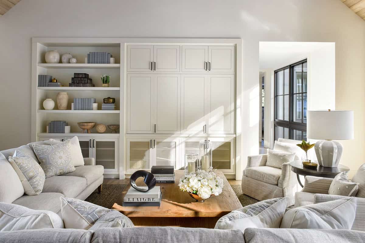 Neutral living room with sectional sofa, built-in cabinetry, and natural light