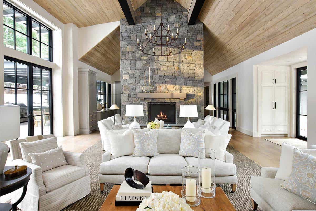 Vaulted great room with stone fireplace, chandelier, and wraparound seating