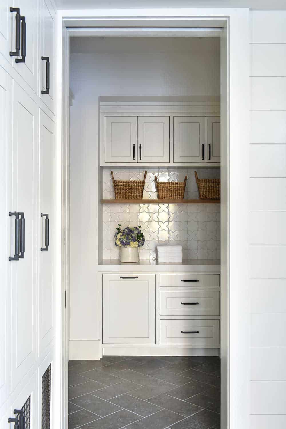 Mudroom nook with patterned tile backsplash and woven storage baskets