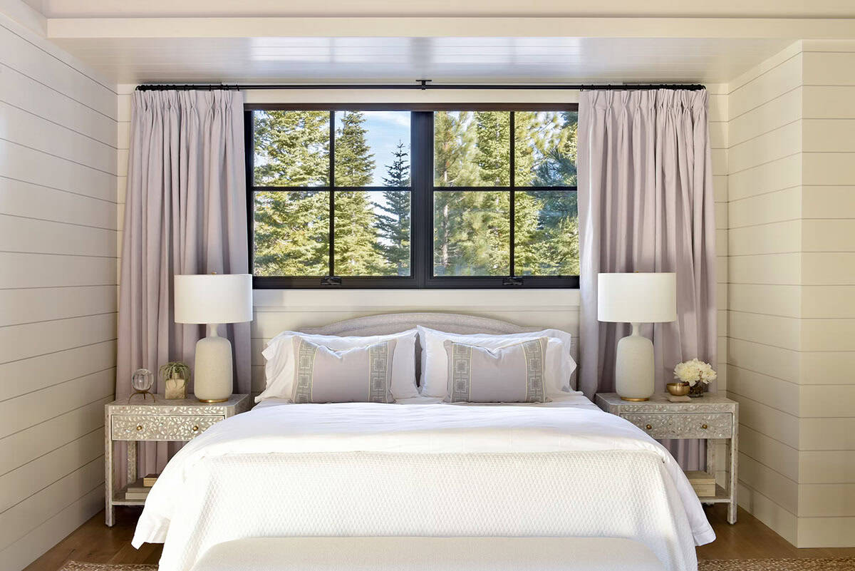 Bedroom nook with striped curtains, bed, and forest-view window
