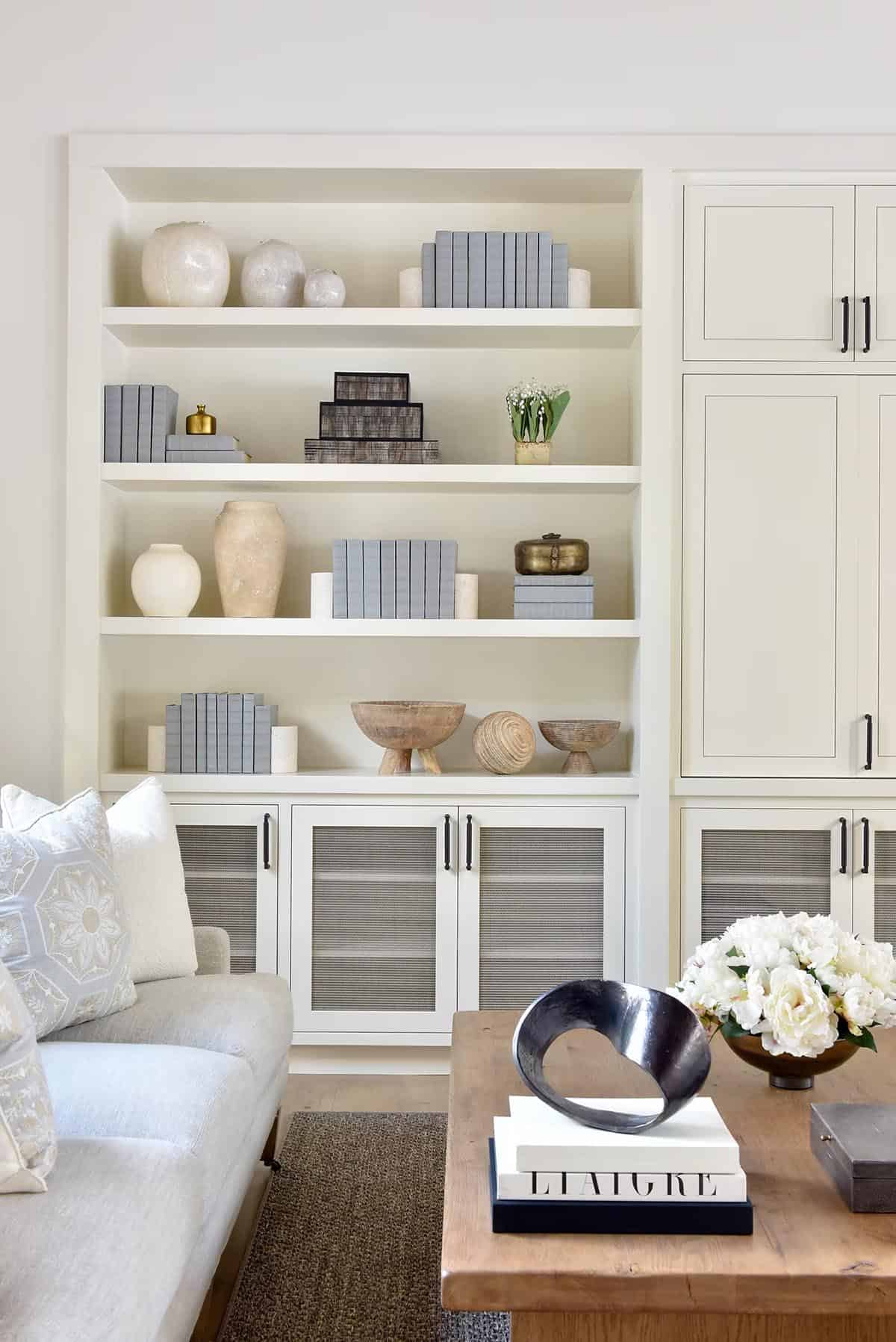 Built-in bookshelf styled with vases, books, and decorative boxes