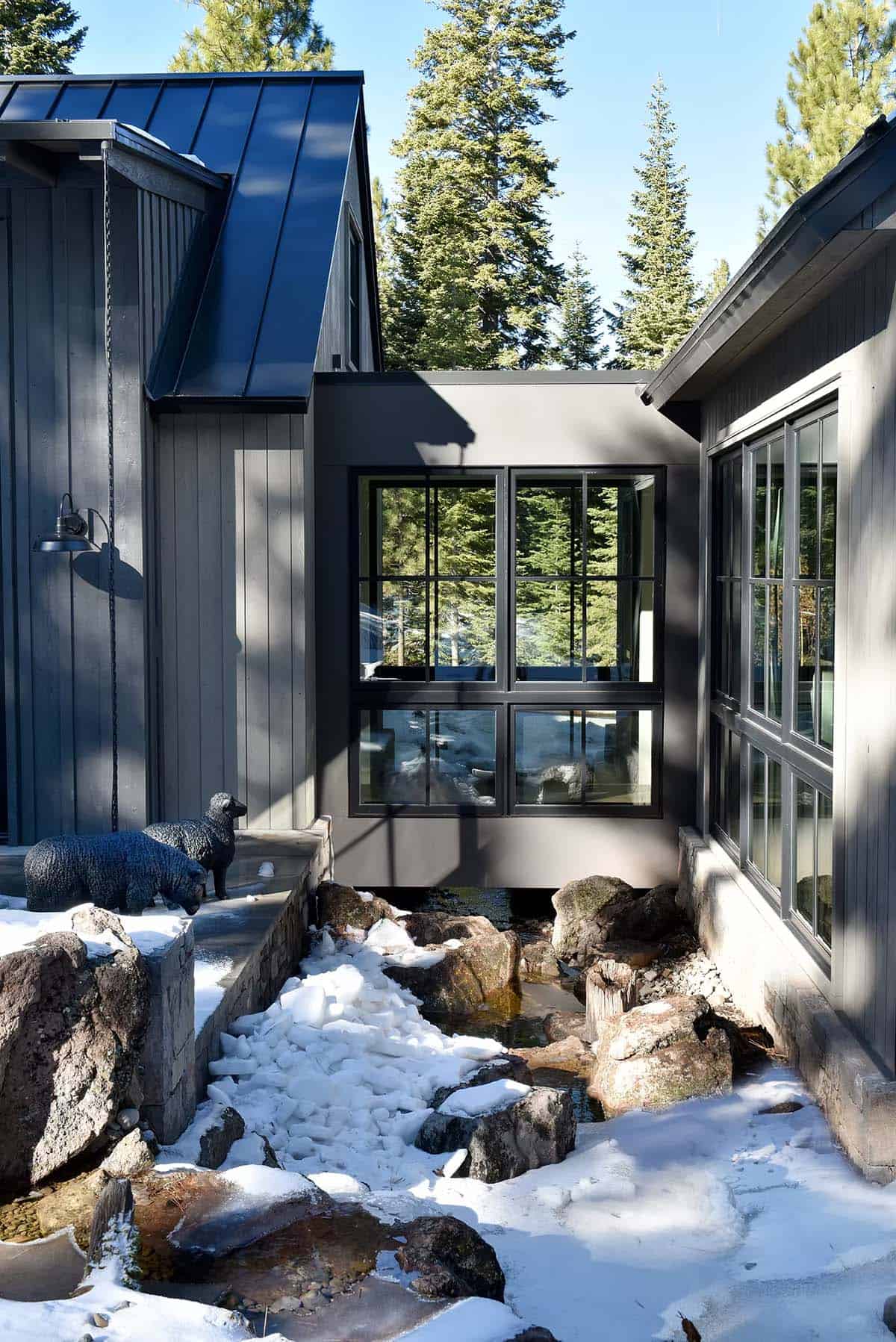 Snowy exterior courtyard with sculpted sheep statues and stream